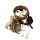 A small basket containing doll accessories and parts including wigs, clothing etc.