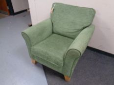A contemporary armchair upholstered in a green fabric