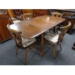 An Ercol elm and beech drop leaf table together with a set of four chairs