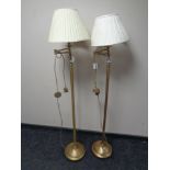 A pair of contemporary brass standard lamps with shades