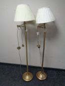 A pair of contemporary brass standard lamps with shades
