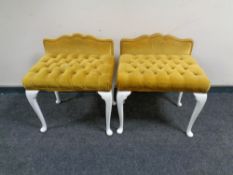 A pair of dressing table stools upholstered in gold buttoned dralon on painted legs