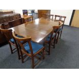 An eight piece 20th century carved oak dining room suite comprising of shaped front sideboard,