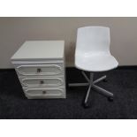 A white three drawer bedside chest and swivel chair