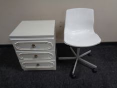 A white three drawer bedside chest and swivel chair