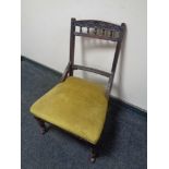 An Edwardian nursing chair upholstered in a gold fabric.