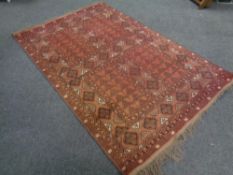 An Ensari Ensi design rug on rust ground, Afghanistan, 250cm by 162cm.