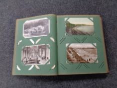 An Edwardian postcard album containing a large quantity of colour and monochrome postcards to