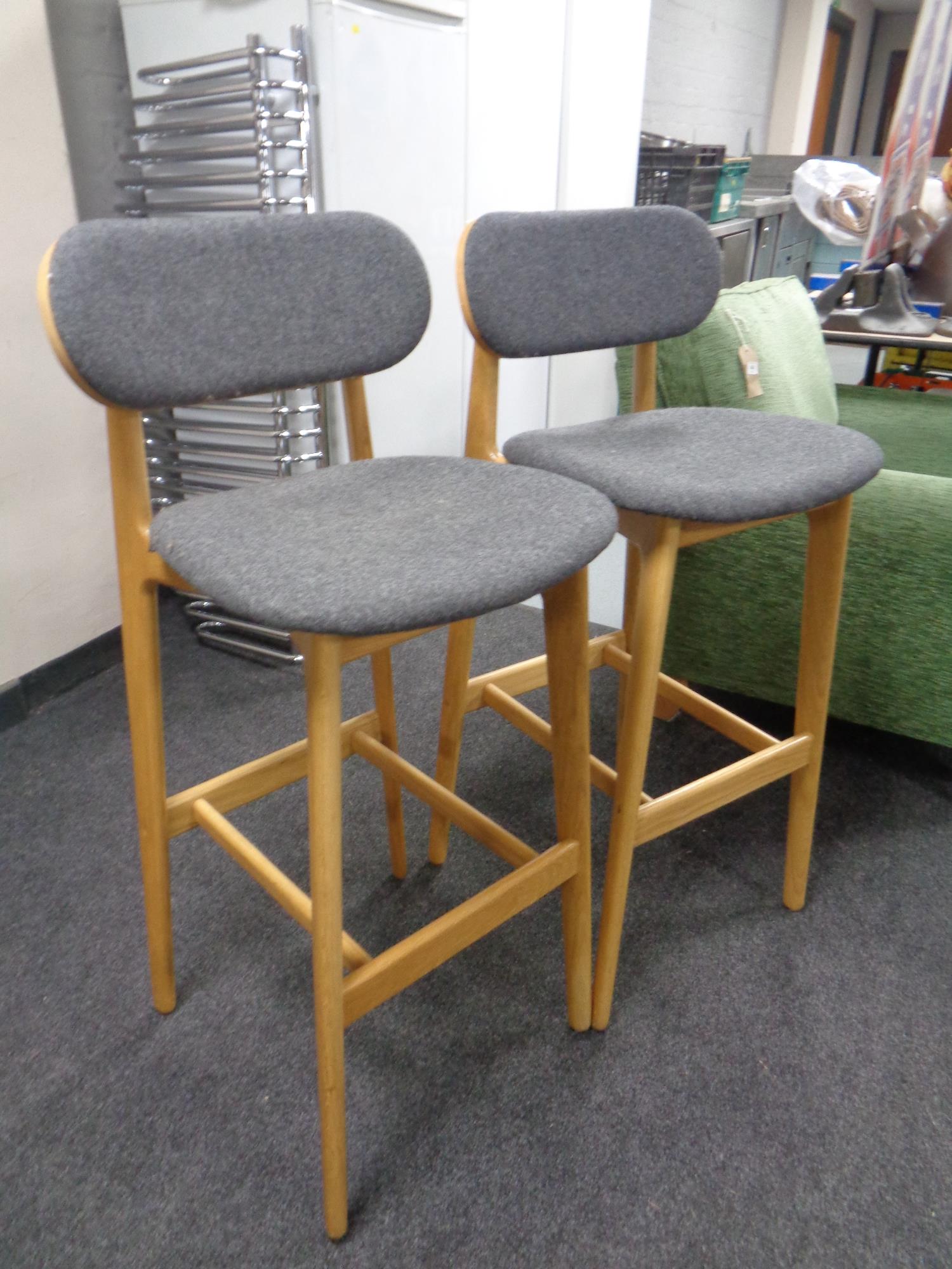 A pair of contemporary oak Modus breakfast bar stools.