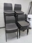 A set of twenty seven black plastic stacking chairs