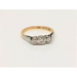 An 18ct gold three stone diamond ring, size M CONDITION REPORT: 2.