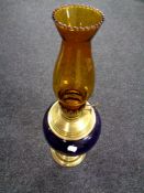 A Duplex brass and porcelain oil lamp with amber glass chimney