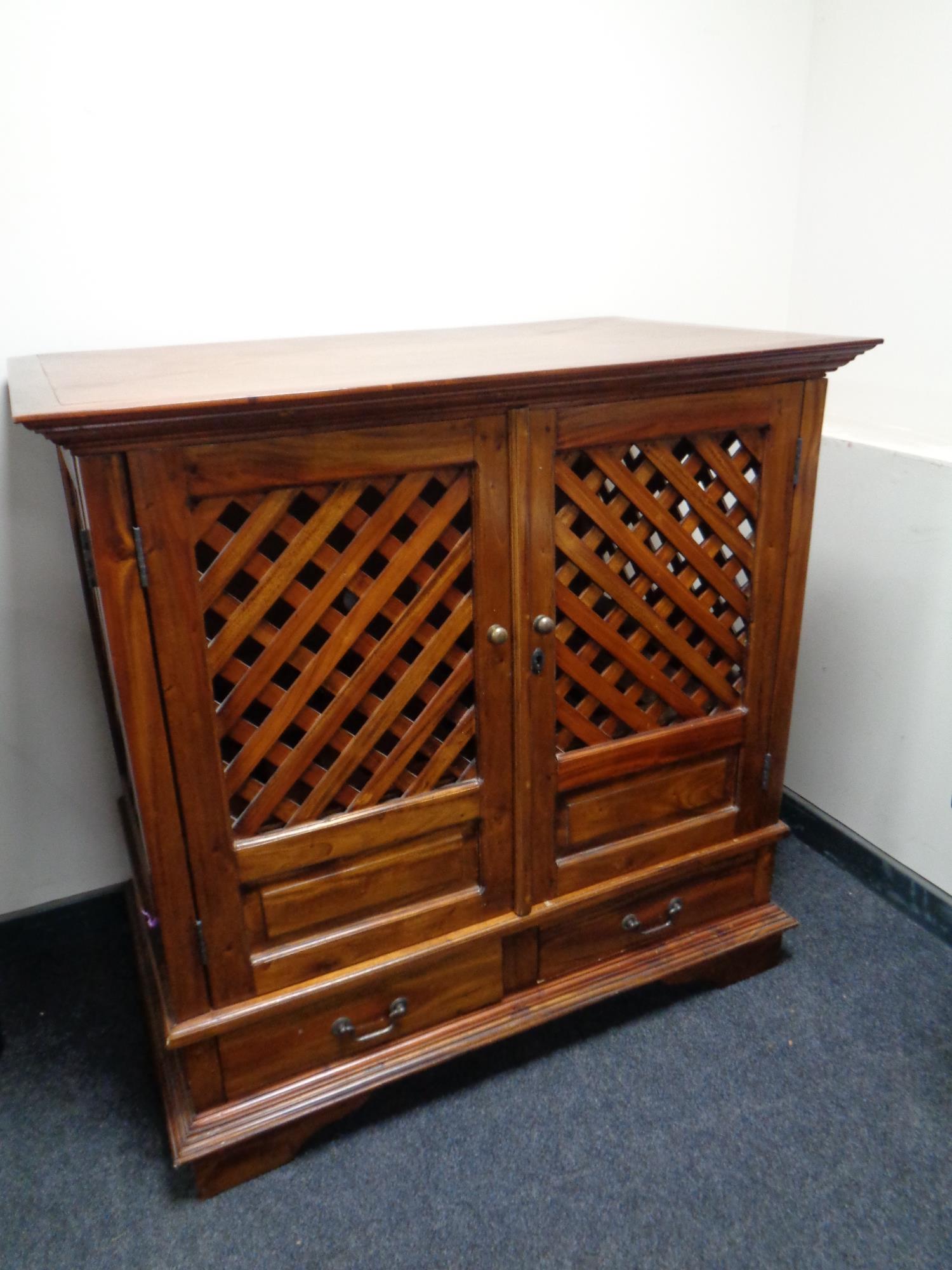 A hardwood double door television cabinet with lattice doors fitted two drawers beneath