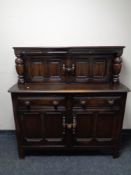 An Ercol elm and beech buffet backed sideboard in antique finish