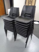 Seventeen black plastic stacking chairs.