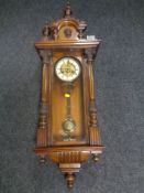 An Edwardian eight day wall clock with brass and enamelled dial.