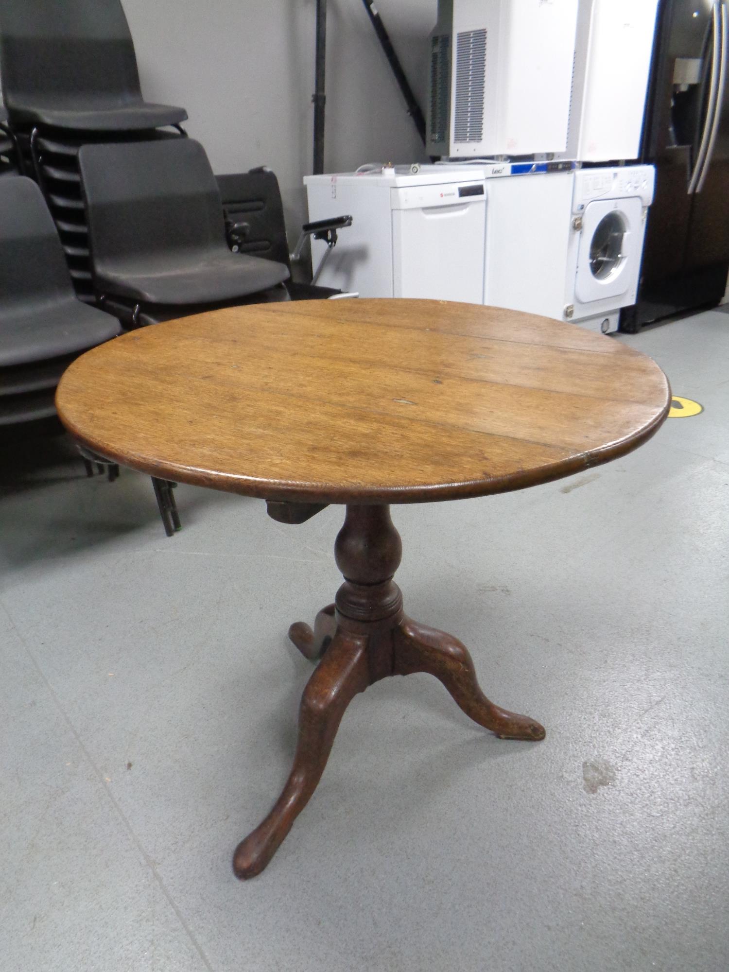 A George III oak tilt top pedestal occasional table.