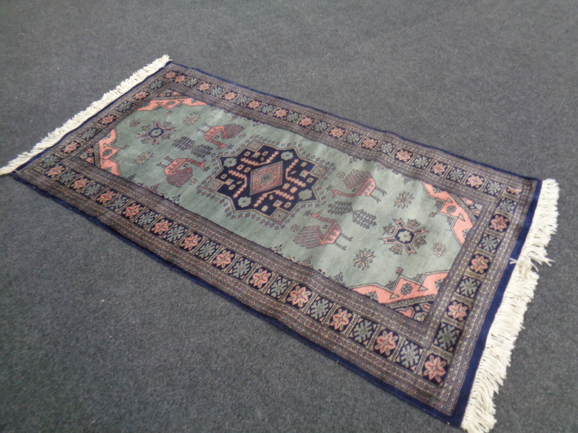 A modern Kazak rug, with stylised birds on blue ground, 183cm by 94cm.