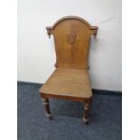 An Edwardian oak hall chair.