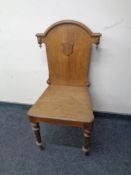 An Edwardian oak hall chair.