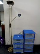 A brass angle poise floor lamp together with two plastic storage chests.