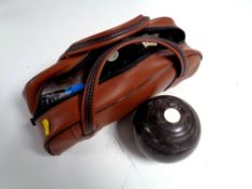 A lawn bowls bag containing two wooden and one composite bowl