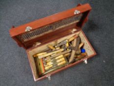 A wooden tool box containing vintage hand tools to include chisel sets, hammers,
