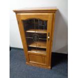 A contemporary audio cabinet with leaded glass door in oak finish