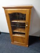 A contemporary audio cabinet with leaded glass door in oak finish