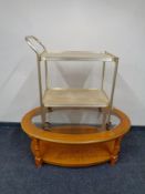 An oval glass topped coffee table with under shelf together with a gilt two tier tea trolley