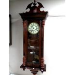 An Edwardian Vienna style wall clock with brass and enamelled dial.