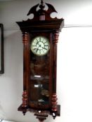 An Edwardian Vienna style wall clock with brass and enamelled dial.