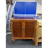 A mahogany and walnut television cabinet on Queen Anne style legs.