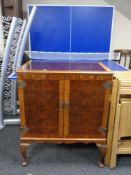 A mahogany and walnut television cabinet on Queen Anne style legs.