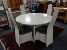 A circular mid century extending table on pedestal together with four high backed chairs