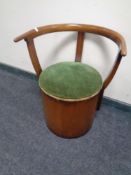 A 20th century stained beech storage elbow chair.