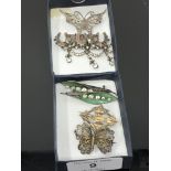 Seven silver brooches including a pair of enamelled leaf examples.