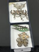 Seven silver brooches including a pair of enamelled leaf examples.