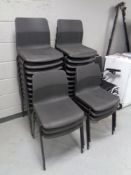 A set of twenty six black plastic stacking chairs