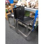 A set of four contemporary black leather and chrome breakfast bar chairs.