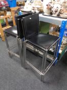 A set of four contemporary black leather and chrome breakfast bar chairs.