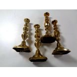A pair of antique brass Queen of Diamonds candlesticks together with another pair.