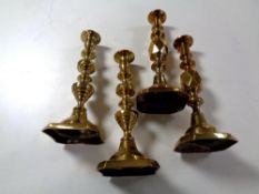 A pair of antique brass Queen of Diamonds candlesticks together with another pair.