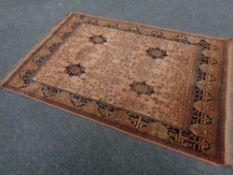 An Afghan rug of geometric design on rust ground, 200cm by 131cm.