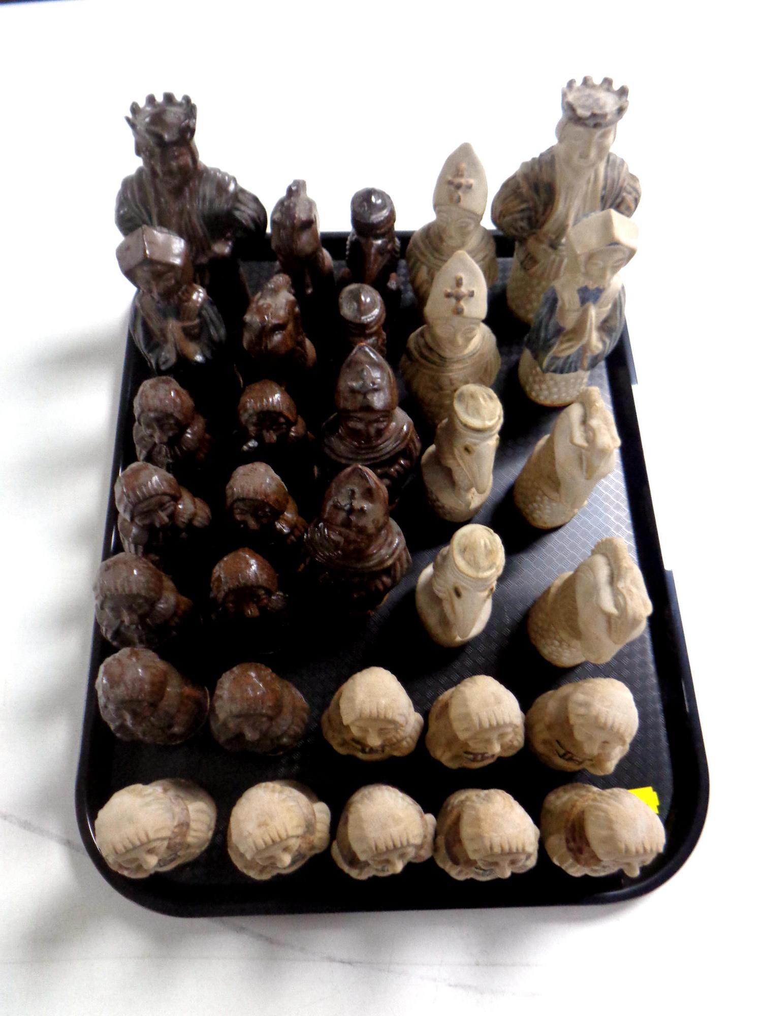 A tray of a set of pottery chess pieces.
