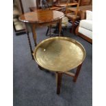 An Edwardian oak occasional table and folding Eastern brass topped table