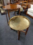 An Edwardian oak occasional table and folding Eastern brass topped table