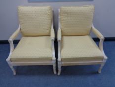 A pair of wood framed armchairs upholstered in a blue and gold fabric