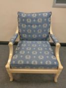 A wood framed armchair upholstered in a classical blue and gold fabric