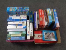A crate and a box containing a large quantity of assorted jigsaws and board games